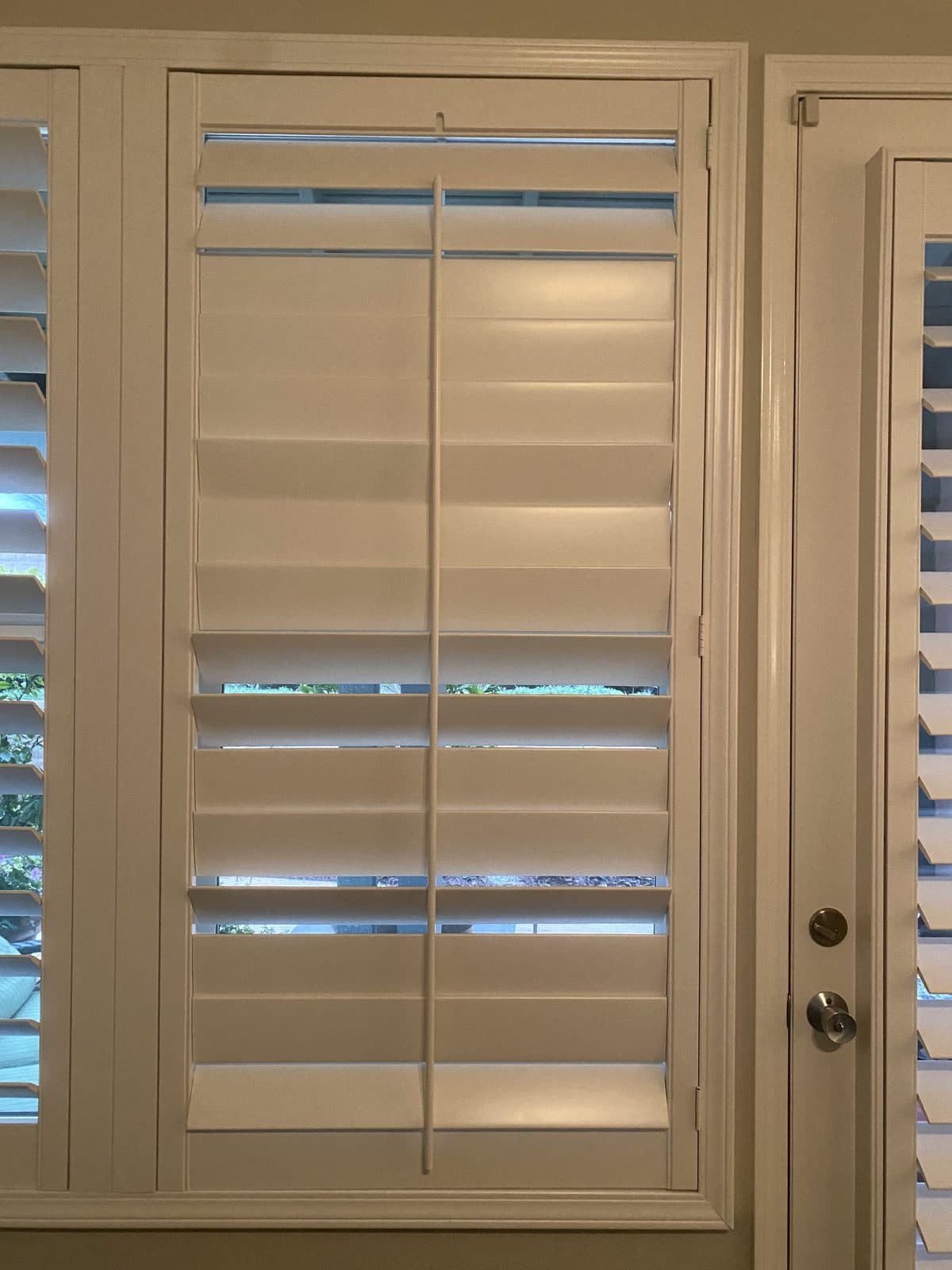 White cafe shutters over a kitchen sink and tiled backsplash. Real AAA Shutter Repair job photo.