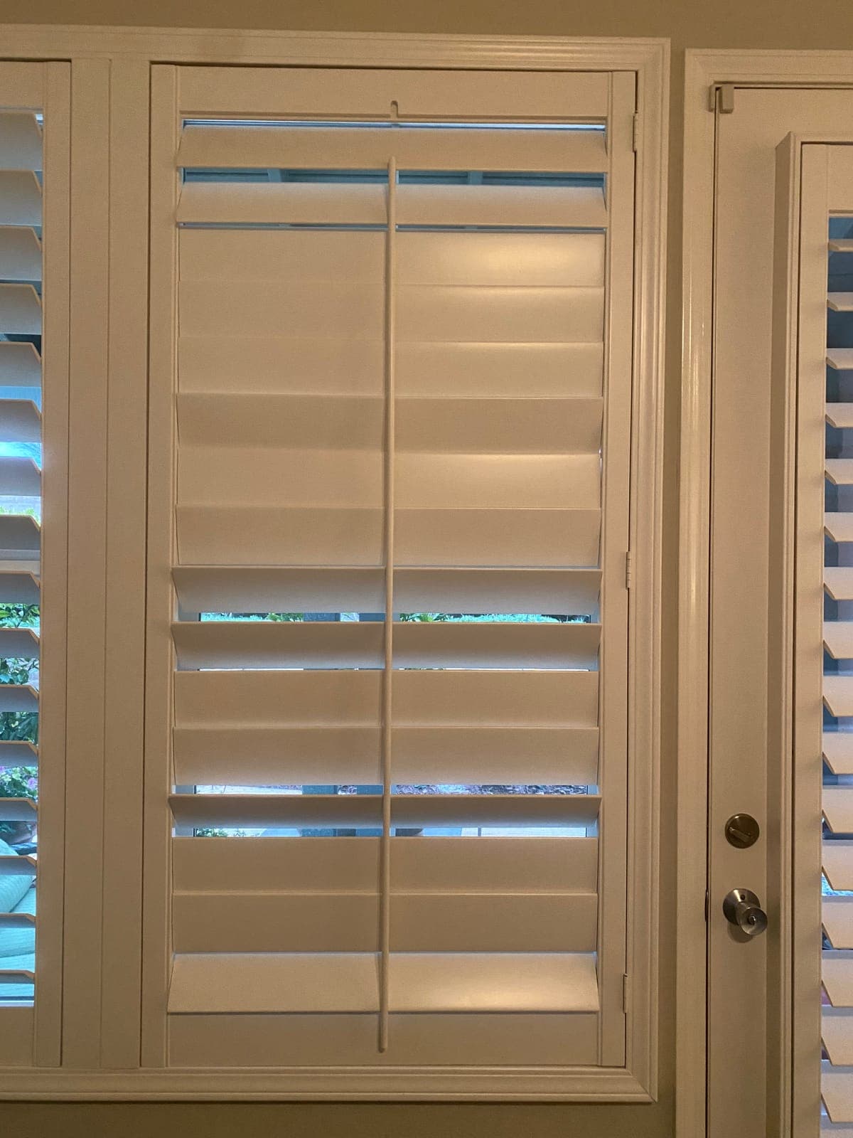 White plantation shutter panel off the window, showing the frame and hinges