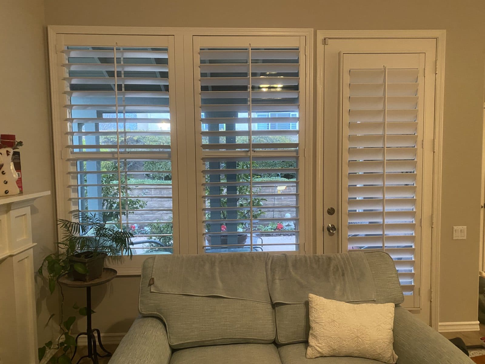 Tier-on-tier white plantation shutters with the lower panels closed. Real AAA Shutter Repair job photo.