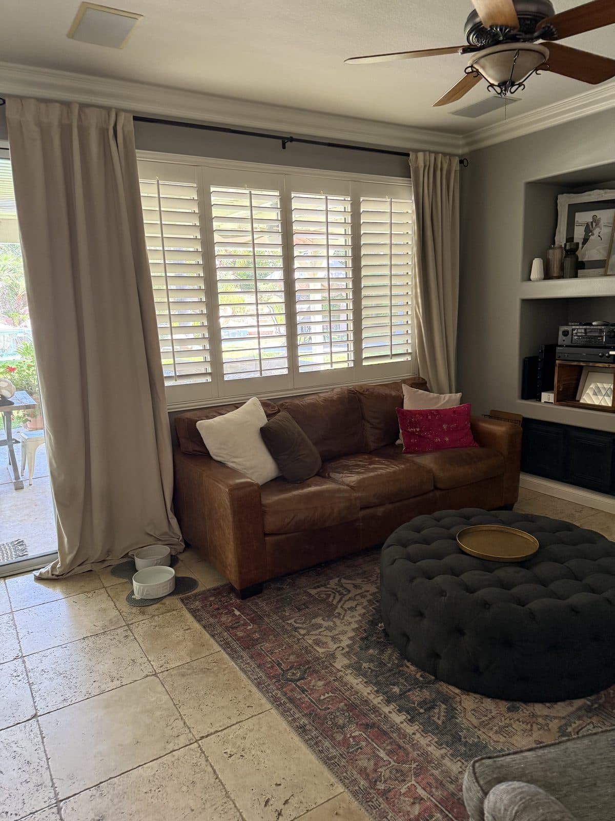 White plantation shutters opened on a bedroom window with a bedside lamp. Real AAA Shutter Repair job photo.