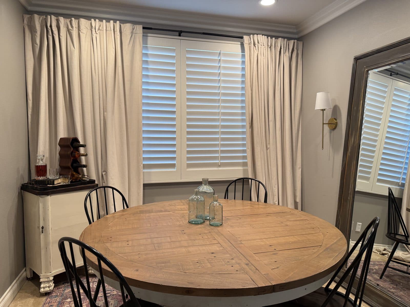 White plantation shutters above a sofa in a living room. Real AAA Shutter Repair job photo.