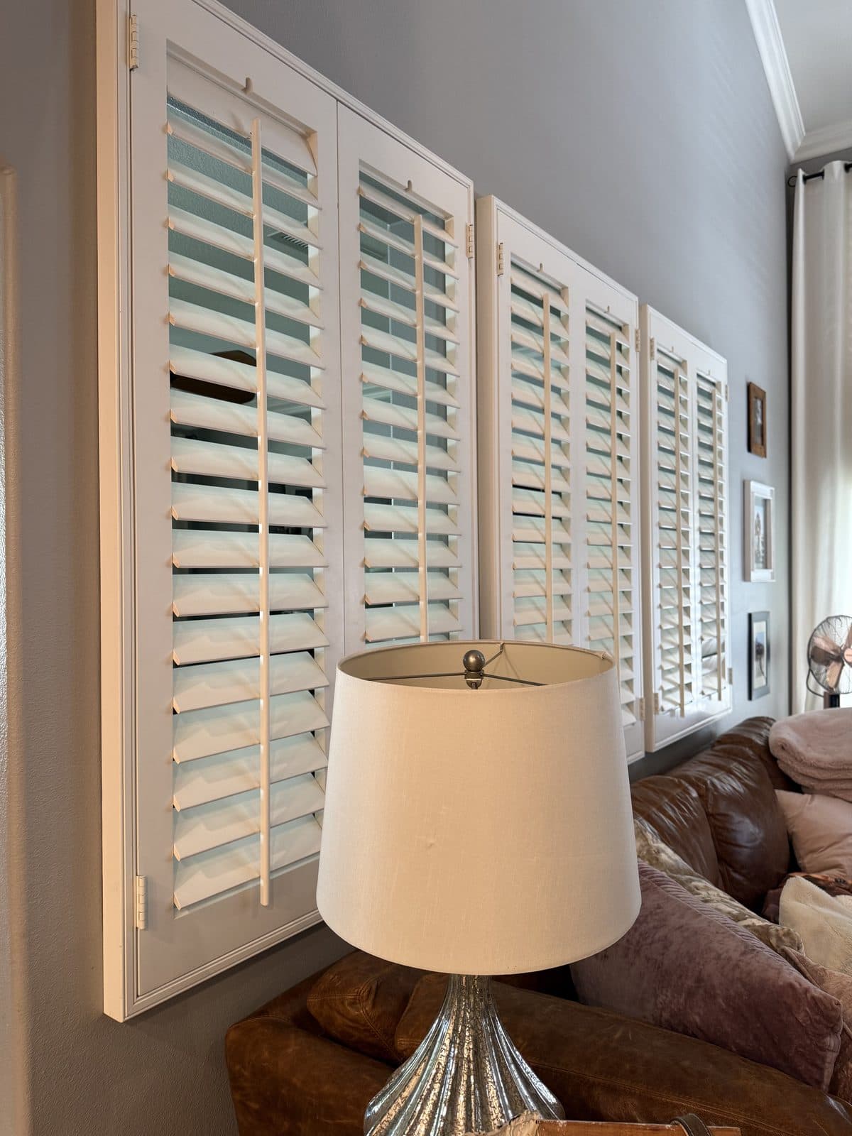 White shutter panels along the bottom track of a sliding glass door. Real AAA Shutter Repair job photo.
